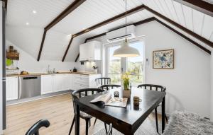 HavrvigにあるLovely Home In Hvide Sande With Wifiのキッチン、ダイニングルーム(テーブル、椅子付)