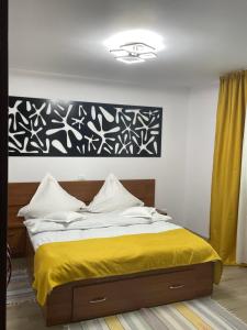 una camera con un letto con una coperta gialla di Vila Emage a Moieciu de Sus