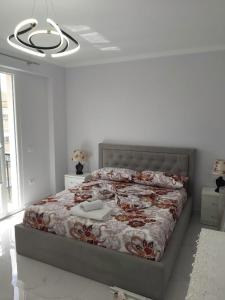 - une chambre avec un lit doté d'un couvre-lit fleuri dans l'établissement Luxury Apartment Korca, à Korçë