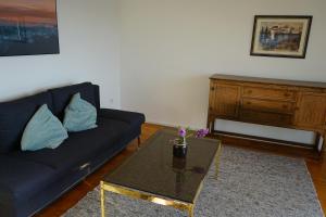 sala de estar con sofá azul y mesa en Ferienwohnung Aribo, en Seeon-Seebruck