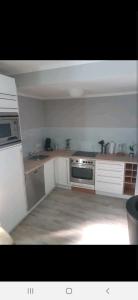 uma cozinha com armários brancos e um forno com placa de fogão em City Ferienhaus in Neheim em Arnsberg