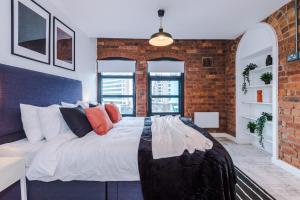 a large bed in a room with a brick wall at Luxury Oversized Urban Apartment with Signature Bathroom in Leeds