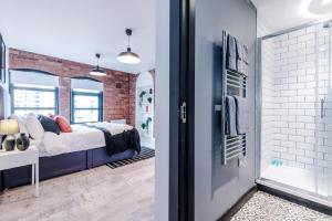 a bedroom with a bed and a brick wall at Luxury Oversized Urban Apartment with Signature Bathroom in Leeds