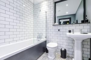 a white bathroom with a sink and a toilet at Luxury Oversized Urban Apartment with Signature Bathroom in Leeds