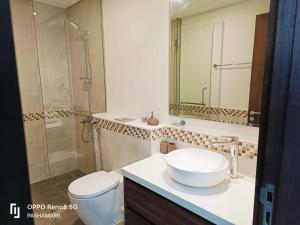 a bathroom with a sink and a toilet and a shower at Reva Residence Luxurious 2 BHK in Dubai