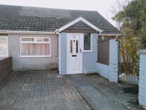uma casa com uma porta branca e uma entrada de tijolos em 3-Bedroom house with Sea view balcony em Swansea