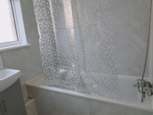 een douche met een douchegordijn in de badkamer bij 3-Bedroom house with Sea view balcony in Swansea