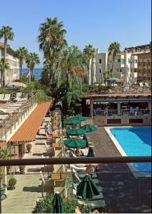 uma vista para um resort com uma piscina e guarda-sóis verdes em Ambassador Hotel & Spa- All Inclusive em Antalya