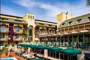 アンタルヤにあるAmbassador Hotel & Spa- All Inclusiveのリゾートで、プール、テーブル、椅子を提供しています。