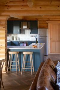 a kitchen with a counter and stools in a cabin at Pheasant's Roost in Foxton