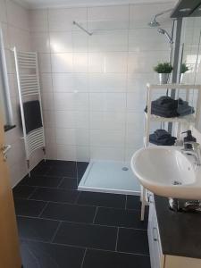 uma casa de banho com um lavatório branco e um chuveiro em City Ferienhaus in Neheim em Arnsberg