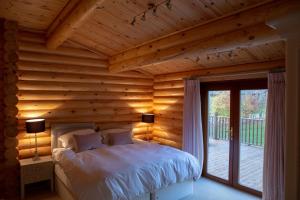 een slaapkamer met een bed in een blokhut bij Pheasant's Roost in Foxton