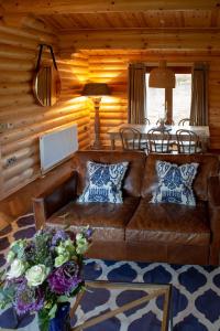 sala de estar con sofá de cuero marrón y mesa en Pheasant's Roost en Foxton
