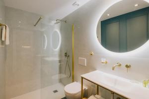 ein Bad mit einer Dusche, einem WC und einem Waschbecken in der Unterkunft Mantzarou Suites by Corfu Collection in Ágios Rókkos