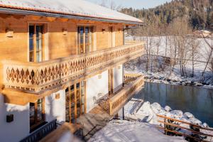 a log home with a balcony in the snow at Chalet in Fischbachau