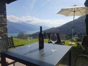 a bottle of wine on a table with two glasses at Agriturismo Nona Rosa in Gravedona