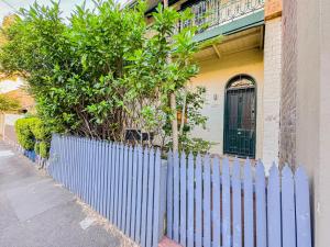 a blue fence in front of a house at Ultimo Terrace Homestay in Sydney