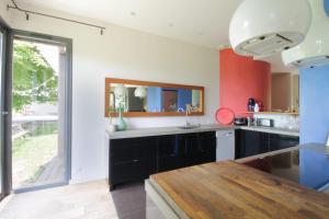 eine Küche mit schwarzen Schränken und einem Holztisch in der Unterkunft Family villa with swimming pool in Aiguebelette-Le-Lac in Aiguebelette-le-Lac