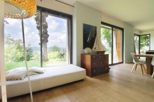 Schlafzimmer mit einem großen Fenster, einem Schreibtisch und einem Tisch in der Unterkunft Family villa with swimming pool in Aiguebelette-Le-Lac in Aiguebelette-le-Lac