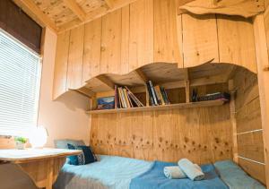 a bedroom with a bed and a wooden wall at OvalMountainLodge - Vacation STAY 34543v in Hakuba