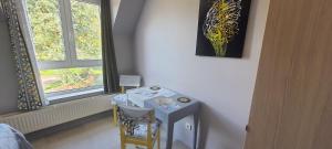 TroisvauxにあるAbbaye de Belvalのテーブルと椅子、窓が備わる客室です。