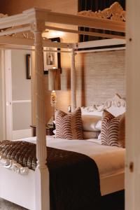 a bedroom with a canopy bed with pillows at Mar Hall Golf & Spa Resort in Bishopton
