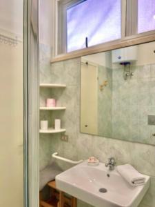 La salle de bains est pourvue d'un lavabo et d'un miroir. dans l'établissement Appartamento I Gigli - By Bolgheri Holiday, à Marina di Bibbona