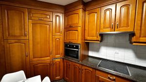 a kitchen with wooden cabinets and a stove top oven at LAR DA REVOLTA in Cedeira