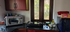 a kitchen with a microwave and a counter top at The Frangipani Marari Beach in Mararikulam +10 photos