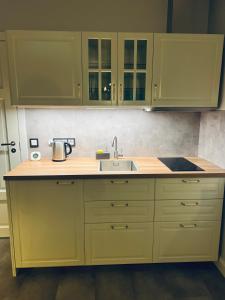 a kitchen with yellow cabinets and a sink at Ikšķiles apartamenti in Ikšķile