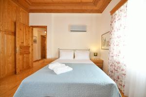 a bedroom with a blue bed with towels on it at Villa Leonard - Comfort Villa in Hydra