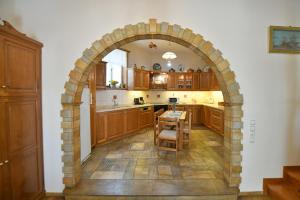 an archway in a kitchen with a table and chairs at Villa Leonard - Comfort Villa in Hydra