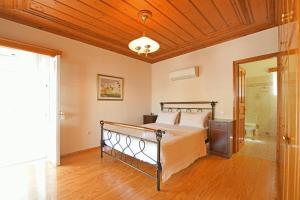 a bedroom with a bed and a wooden ceiling at Villa Leonard - Comfort Villa in Hydra