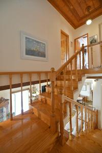 a wooden staircase in a living room with wood floors at Villa Leonard - Comfort Villa in Hydra