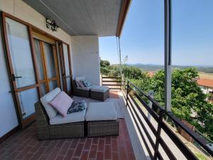 a porch with two chairs and a couch on a balcony at A casa di Daniela in Massa Marittima