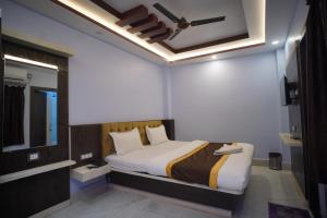 Hotel Asha Inn في Jasidih: غرفة نوم بسرير كبير بسقف