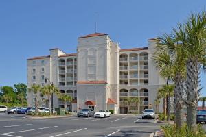 a large white building with cars parked in a parking lot at Barefoot Yacht Club Villas - 1-805 in Myrtle Beach