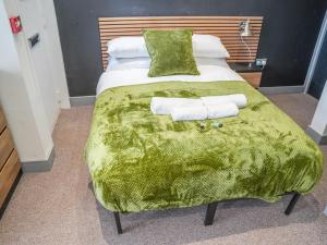 a bedroom with a bed with two towels on it at Modern cosy retreat Pass the Keys in Beeston