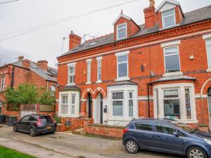 a blue car parked in front of a brick house at Modern cosy retreat Pass the Keys in Beeston