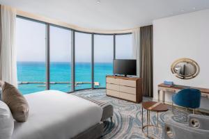 エル・アラメインにあるRixos Premium Alameinのベッドとテレビが備わるホテルルームです。