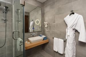 a bathroom with a sink and a shower at Rixos Premium Alamein in El Alamein