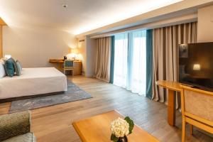 Cette chambre comprend un lit et une grande fenêtre. dans l'établissement Ana Hotels Europa Eforie Nord, à Eforie Nord