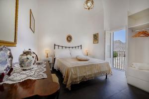 una camera da letto con un letto, un tavolo e una finestra di Ai Due Leoni 1863 a Ragusa