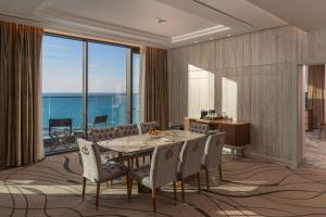 a dining room with a table and chairs at Rixos Premium Alamein in El Alamein