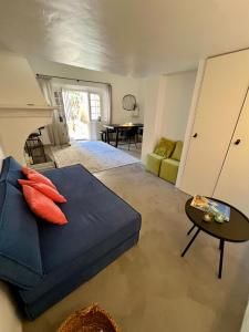 uma sala de estar com um sofá azul e uma mesa em Belle Maison de village em Ramatuelle