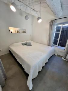 um quarto com uma cama branca num quarto com uma janela em Belle Maison de village em Ramatuelle