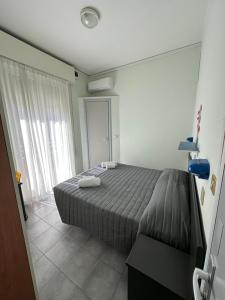 a bedroom with a bed with two towels on it at Hotel Austria in Rimini