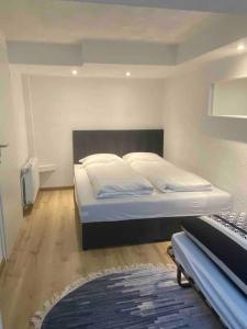 ein Schlafzimmer mit einem großen Bett und weißen Kissen in der Unterkunft Gästewohnung in Günzburg in Günzburg