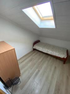 Cette petite chambre comprend un lit et une lucarne. dans l'établissement Lux Apartment Meecoon, à Podgorica