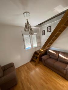 - un salon avec un canapé et un escalier dans l'établissement Lux Apartment Meecoon, à Podgorica